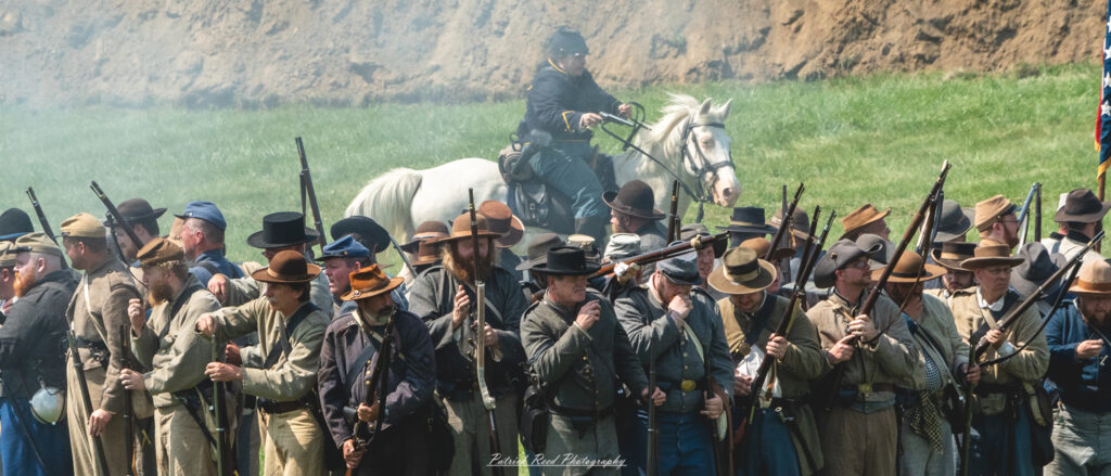 Union cavalry soldiers charging forward in an aggressive attack against Confederate positions, their horses galloping at full speed. Dressed in blue uniforms, the cavalry members wield sabers and pistols, embodying the energy and intensity of battle as they engage the enemy with determination and bravery.